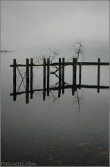 Close up of old pier on Loch Earn, St. Fillans with a driftwood branch stuck on it